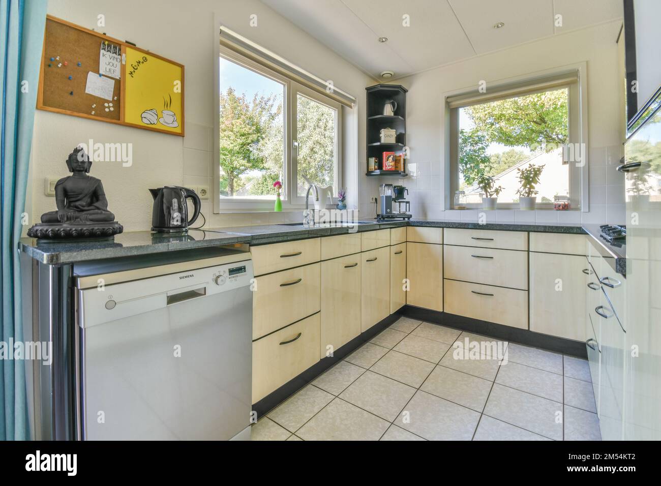 a kitchen area with white cabinets and black counter tops on the counters in this photo is taken from the inside Stock Photo