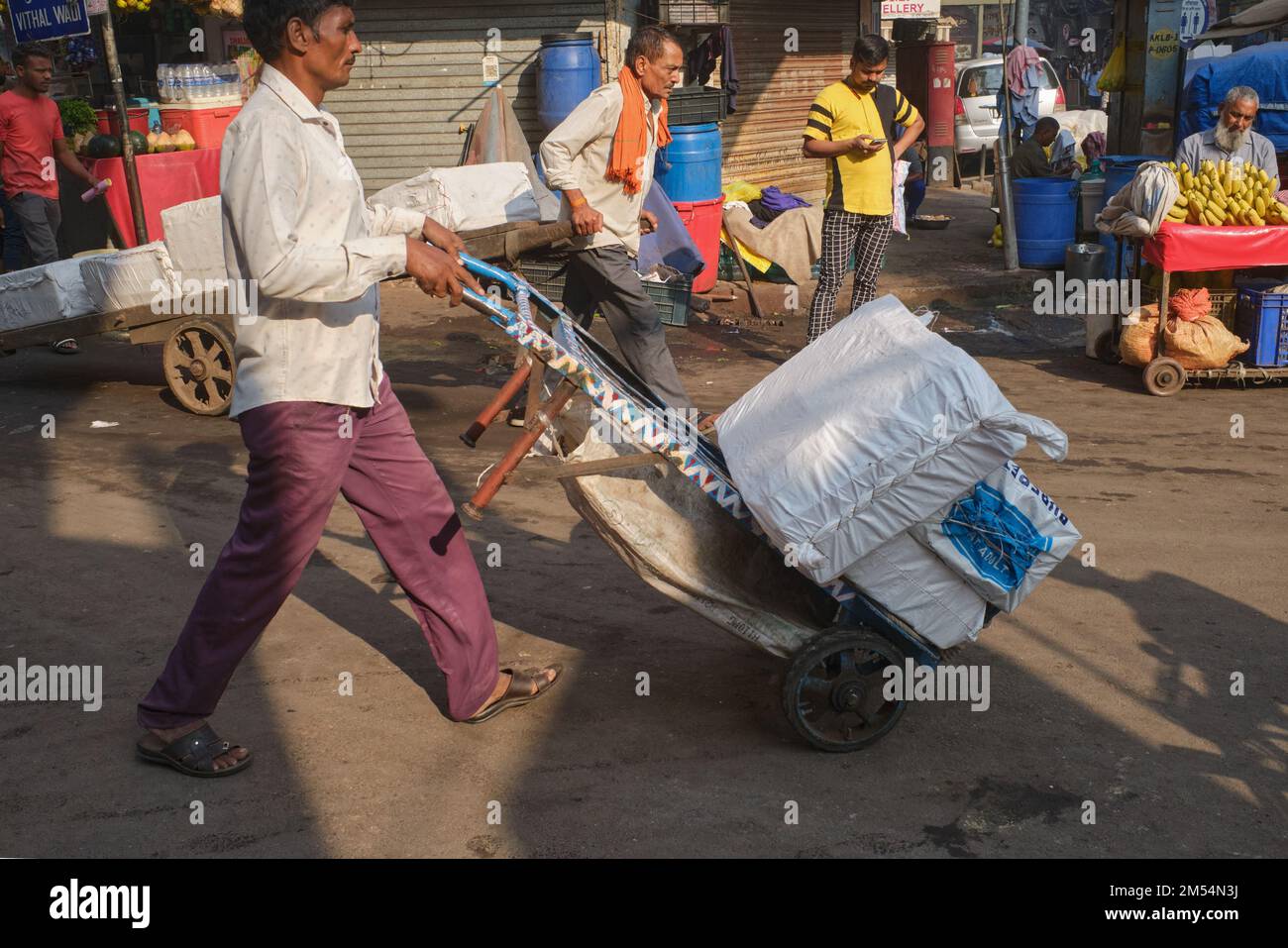 Porters with their trolleys, migrants from Northern India, transporting goods in Zaveri Bazar market area in Mumbai, India Stock Photo