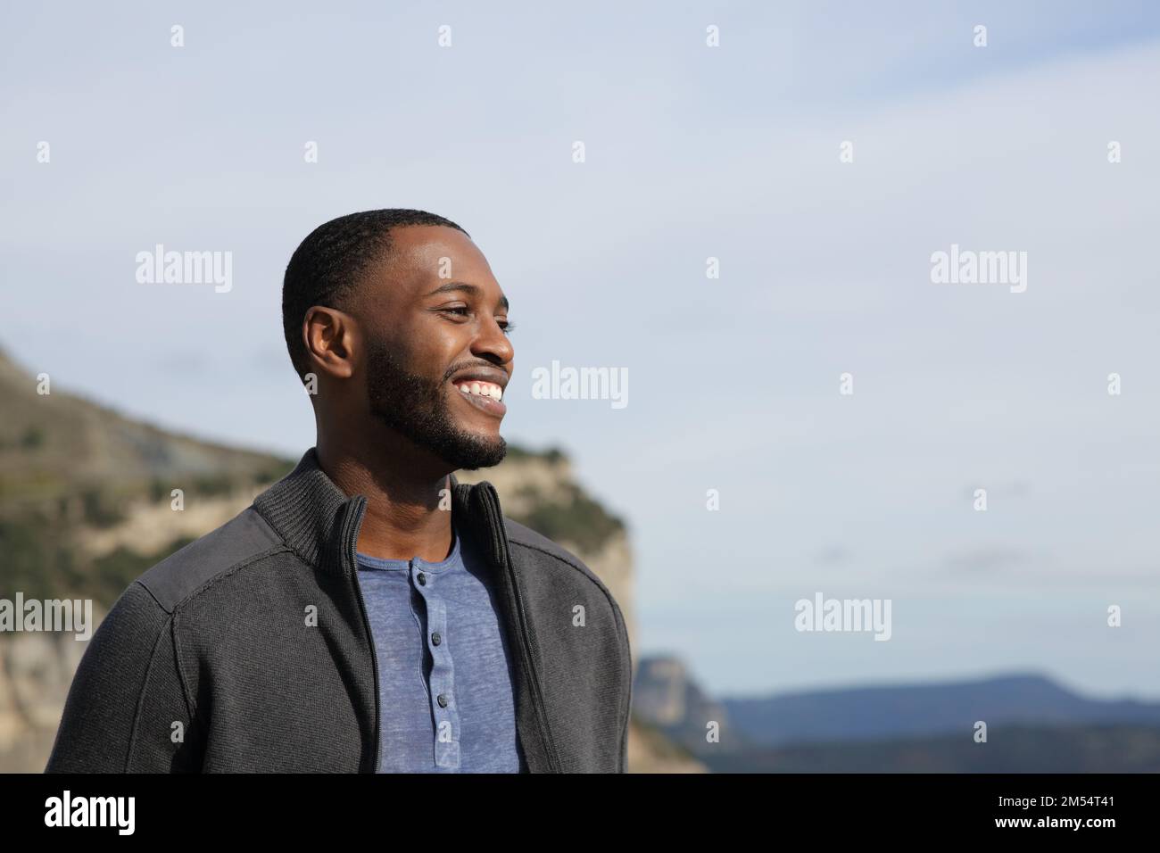 Happy black man contemplating views smiling in nature Stock Photo