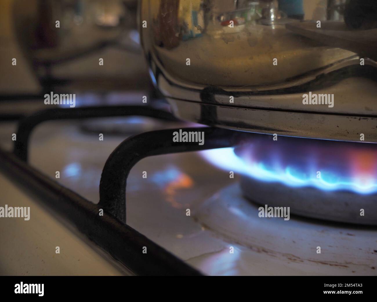 Pot on the gas stove. Burning gas burners. Flames on gas hob. Gas cooker with burning flames of propane gas Stock Photo