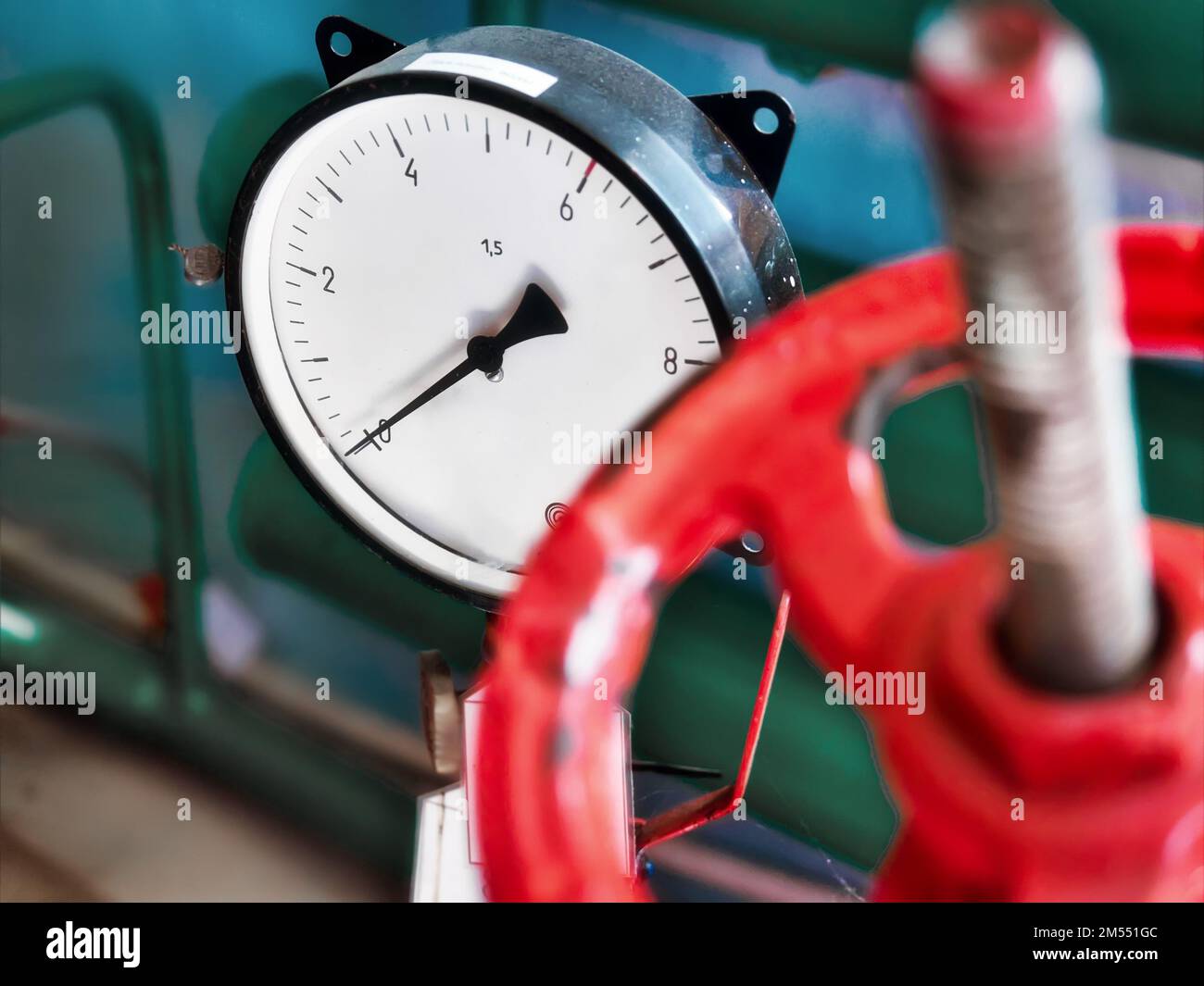 Red valve and pressure sensor on the gas supply or heating pipe.. Stock Photo