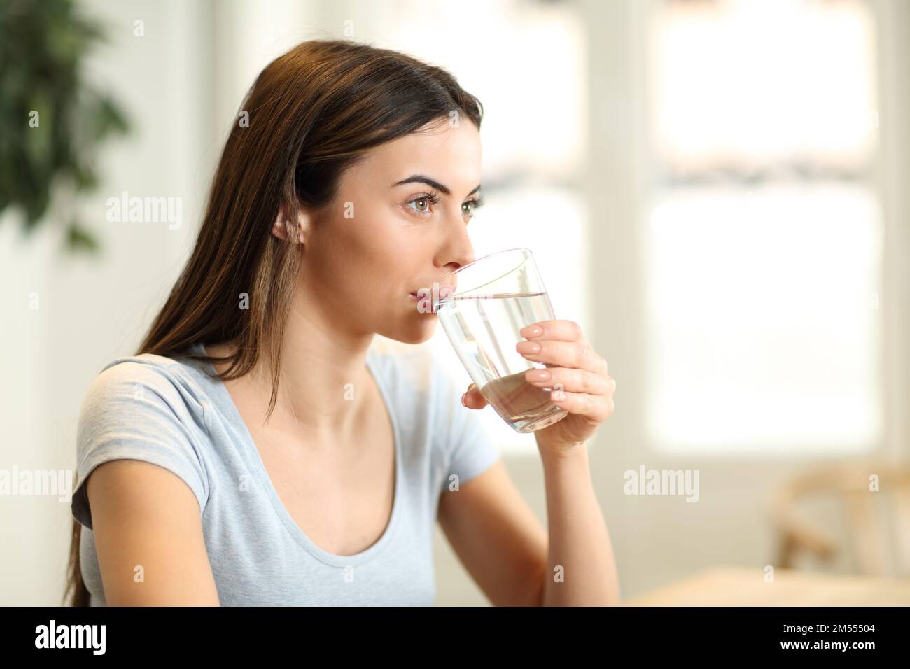 Woman drinking water from glass at home Stock Photo Alamy