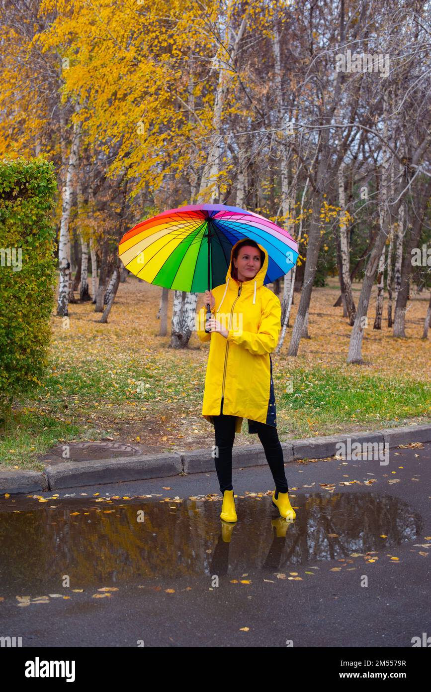 a girl under an umbrella in the rain walks in the park Stock Photo