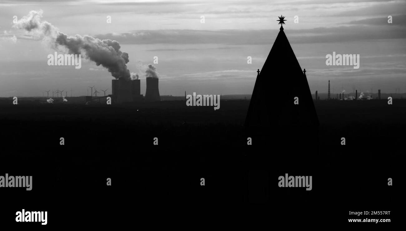 Silhouette of steeple and industrial power plant in background. Stock Photo