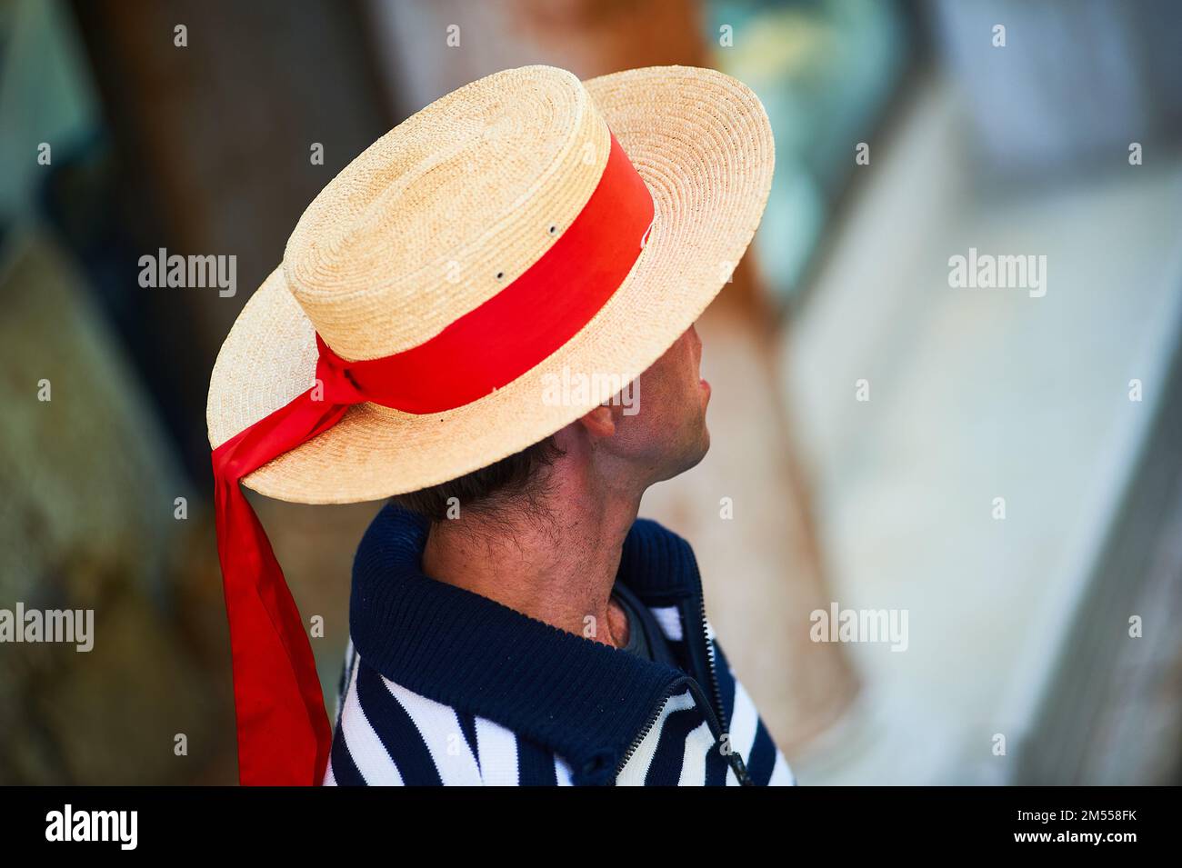 Person with Venetian gondolier hat and red bow, Venice, Italy Stock Photo