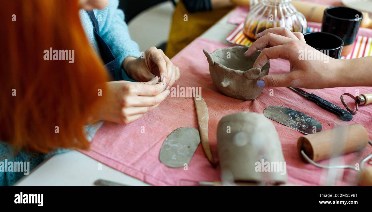 Pottery workshop class. A pottery crafts dish from a raw clay. Creating ceramics for adults Stock Photo