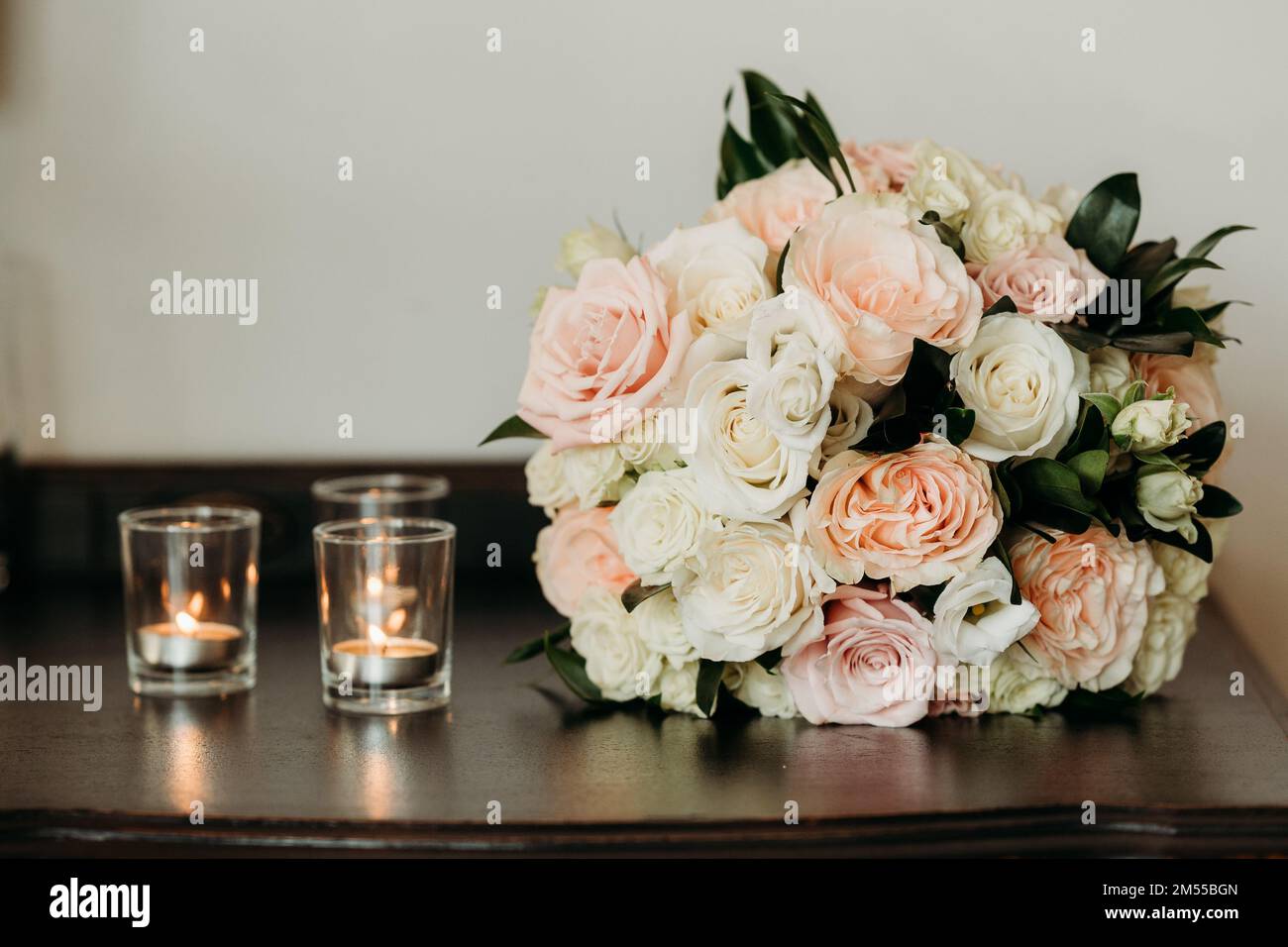 The delicate wedding flower bouquet and the lit candles during the