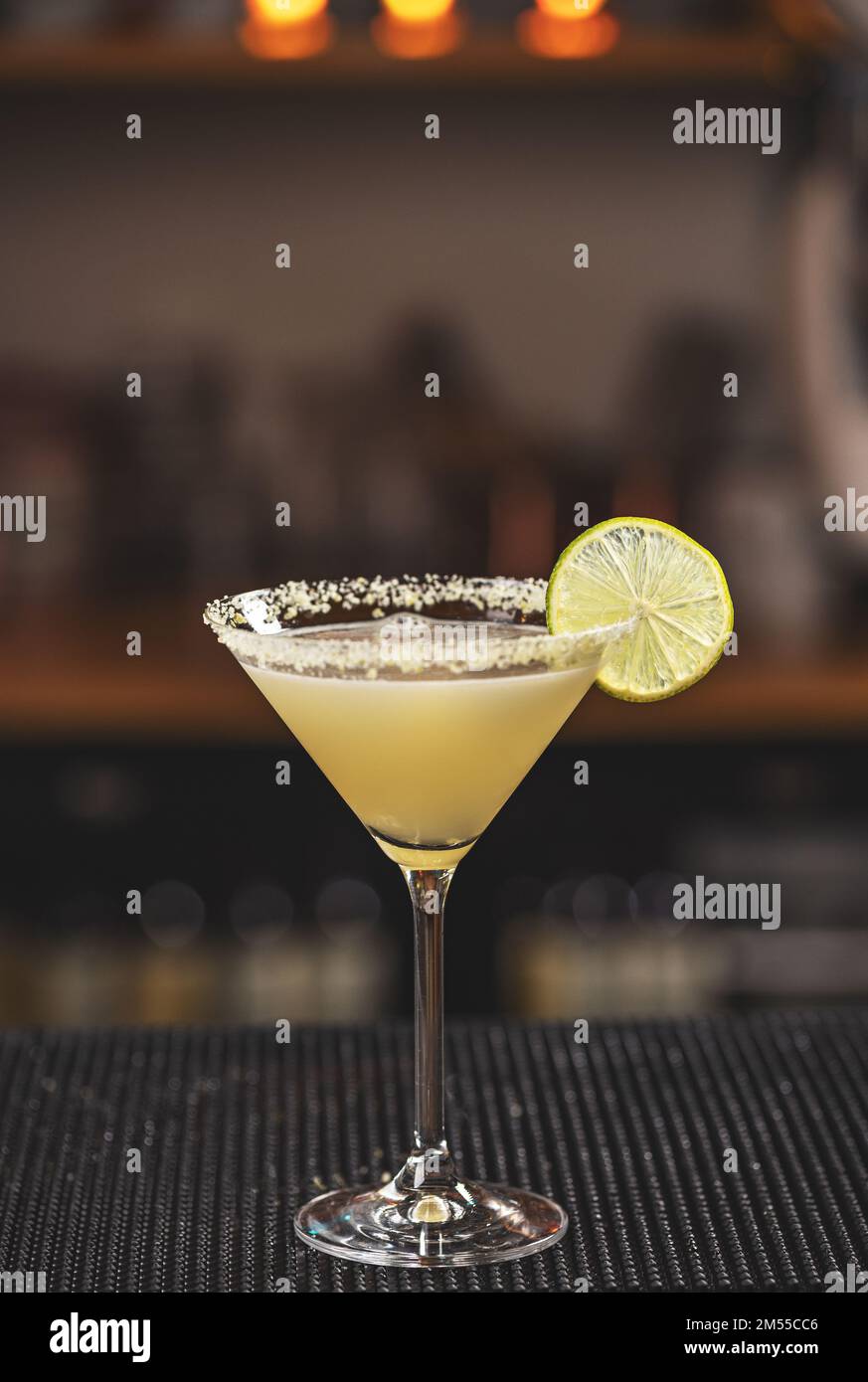 Lemonade martini cocktail garnished with lemon served on bar counter