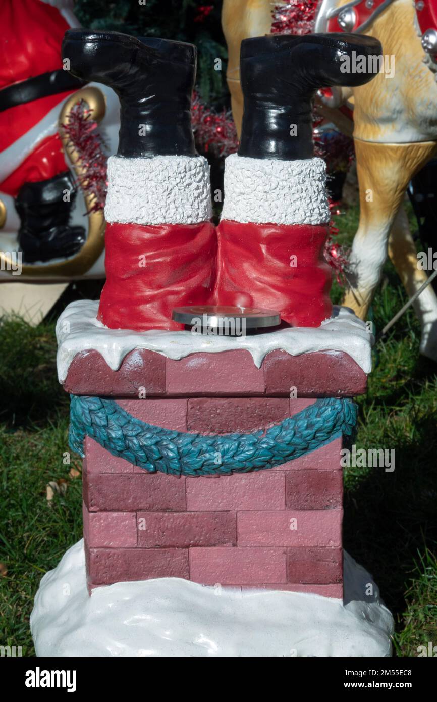 A Christmas lawn decoration depicting Santa going down a chimney head first. In Queens, New York City. Stock Photo