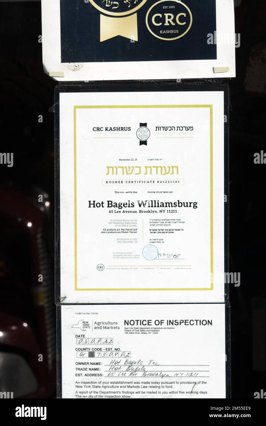 A bilingual English Hebrew sign outside HOT BAGELS OF WILLIAMSBURG certifying that sell only kosher food. On Lee Avenue in Williamsburg, Brooklyn, NYC Stock Photo