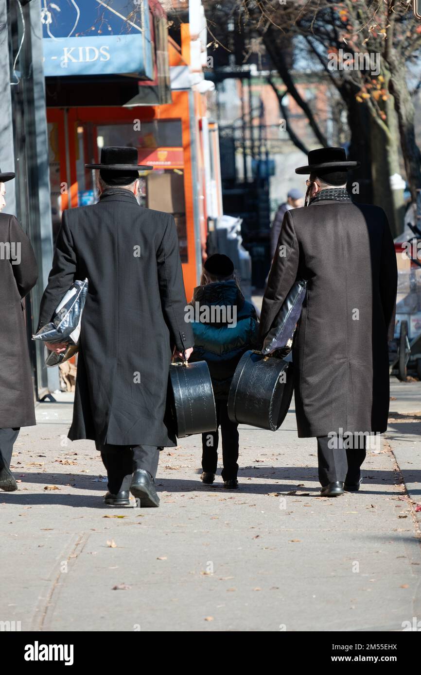 On the day before Chanukkah, 2 orthodox Jewish men carry the shtreimels in boxes to wear while