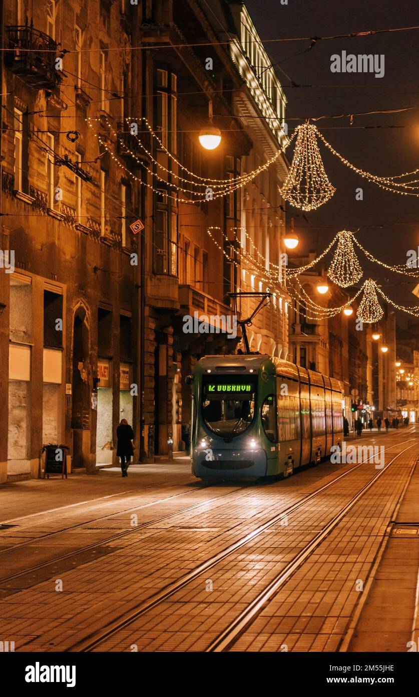 Night photo of tram on street in city of Zagreb decorated with christmas lights in december. Stock Photo