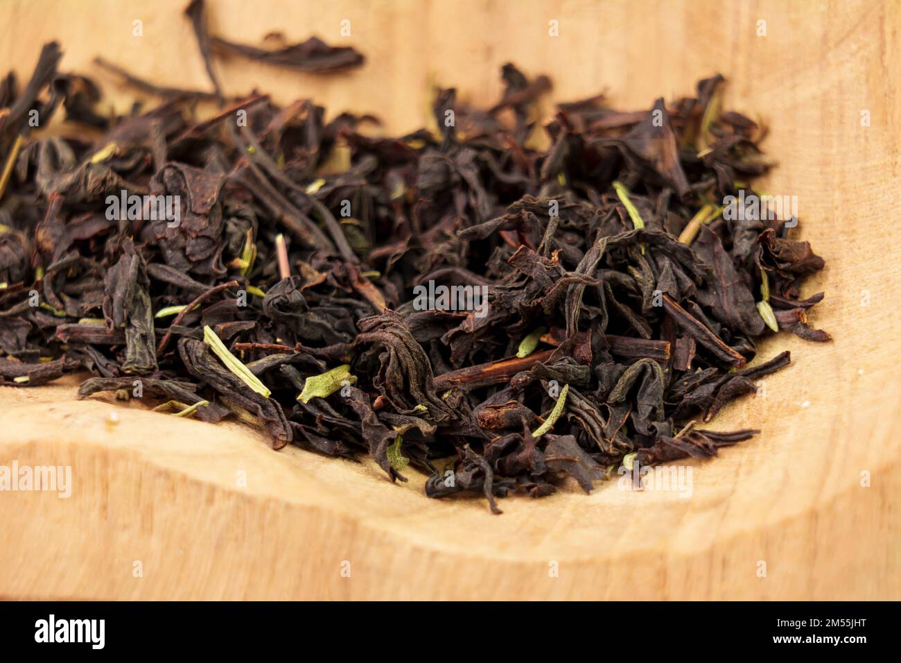 Thyme black tea dried leaves in a wooden bowl. Medicinal herb drink Stock Photo