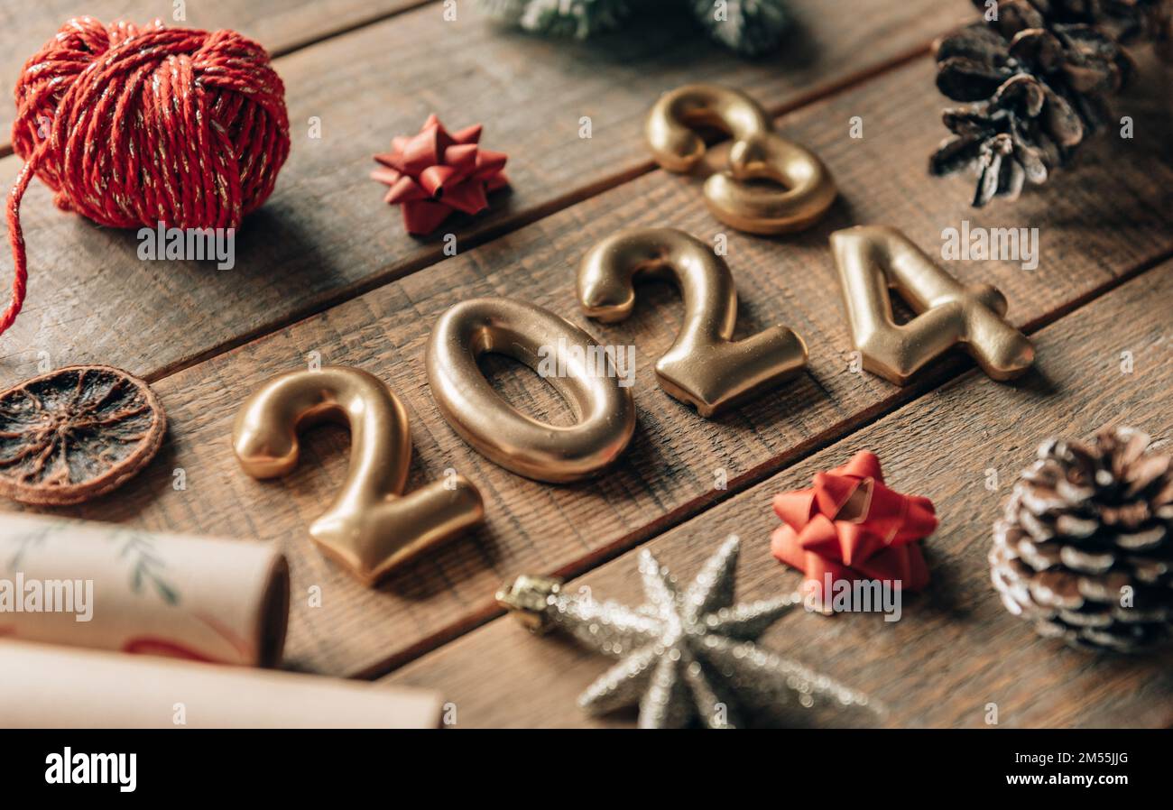 Golden New year 2023 to 2024 numbers on wooden background with chrimas ...