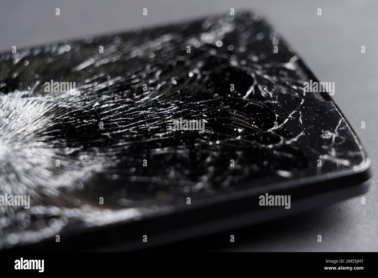 Black smashed crushed mobile phone with broken cracked display. Macro Stock Photo