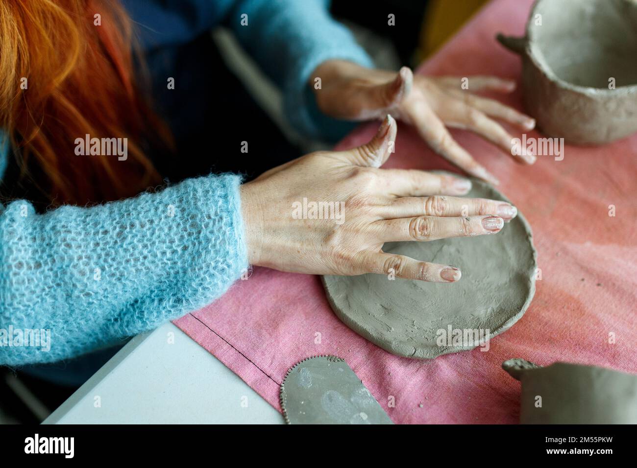 Pottery workshop class. A pottery crafts dish from a raw clay. Creating ceramics for adults Stock Photo