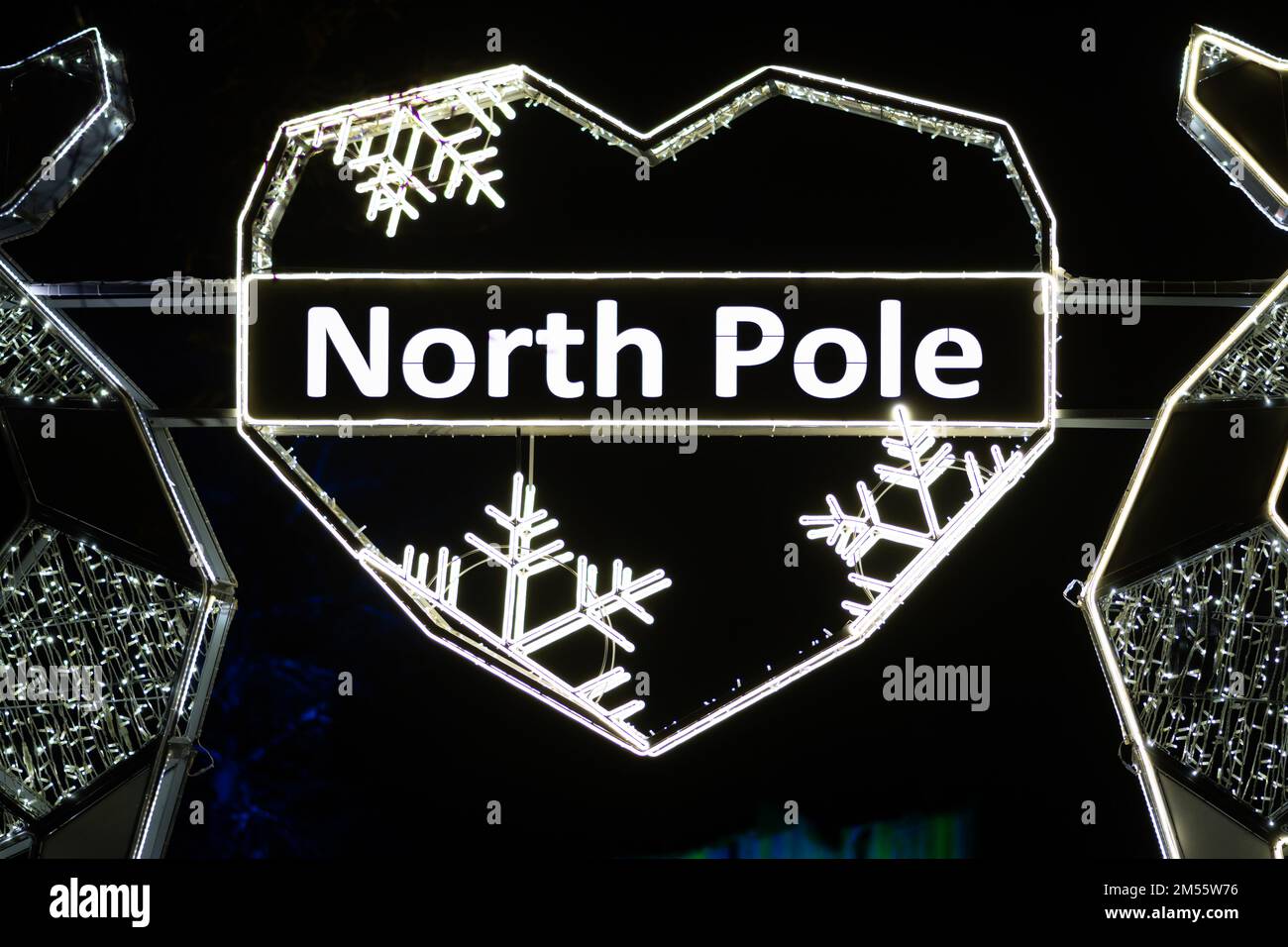 North Pole written in a heart with snowflakes made with the glowing lights, with northern lights and black background Stock Photo