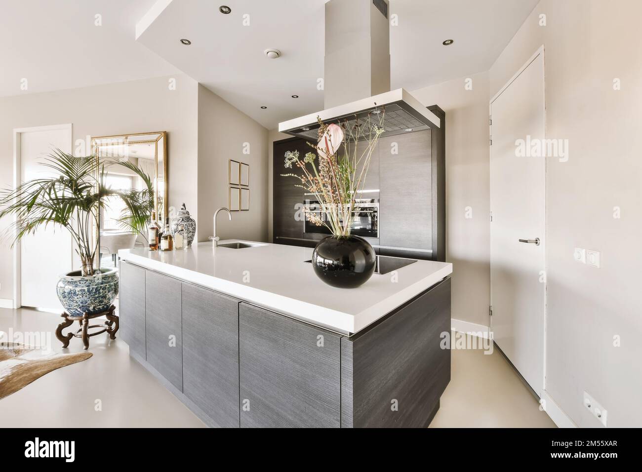 a modern kitchen with grey cabinets and white countertops in the island ...