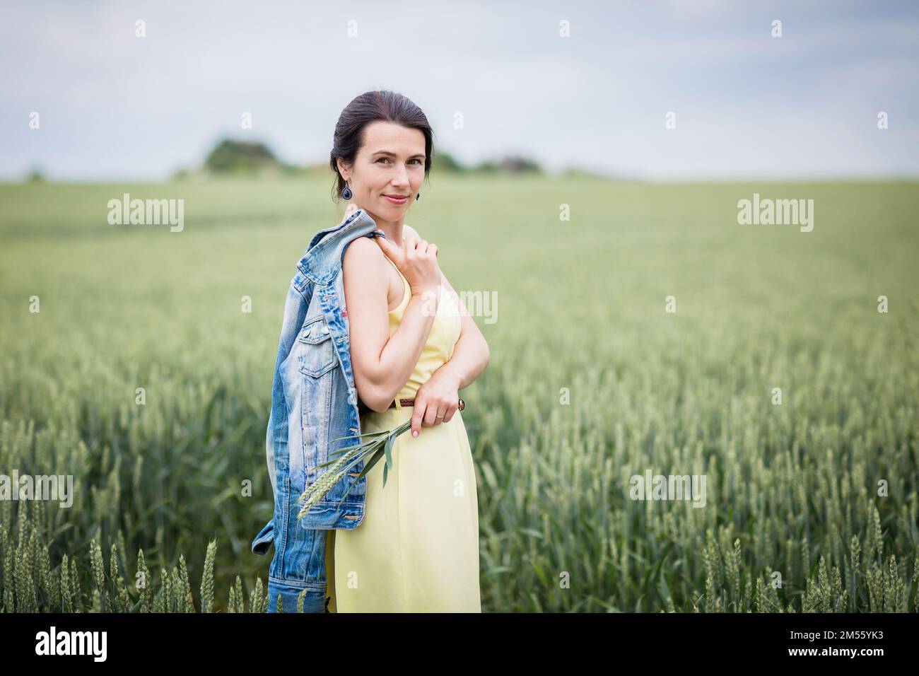 Lifestyle portrait of young stylish woman walking by wheat field Stock ...