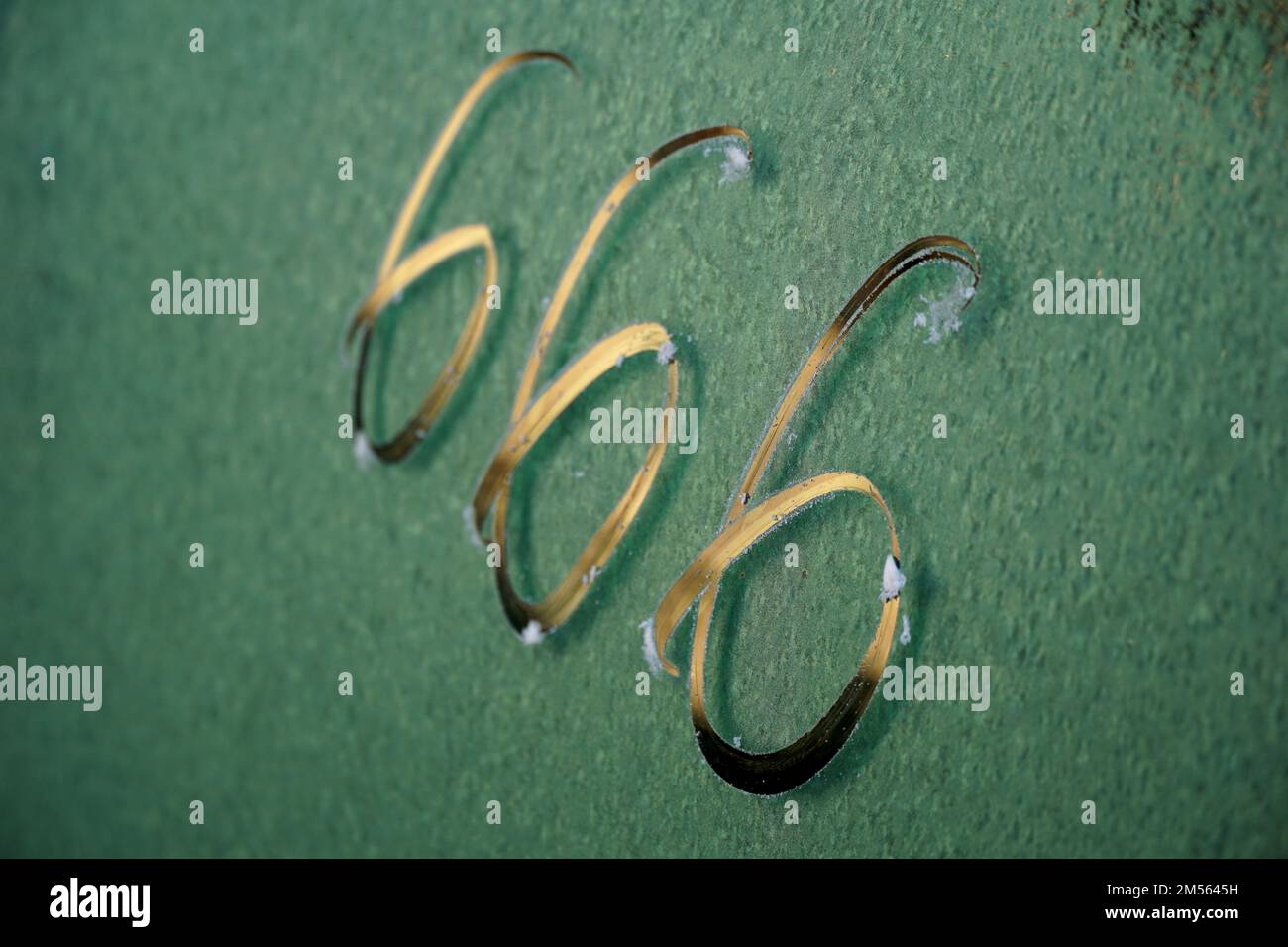 No. 666. The number three sixes in red paint on an old rusty blue