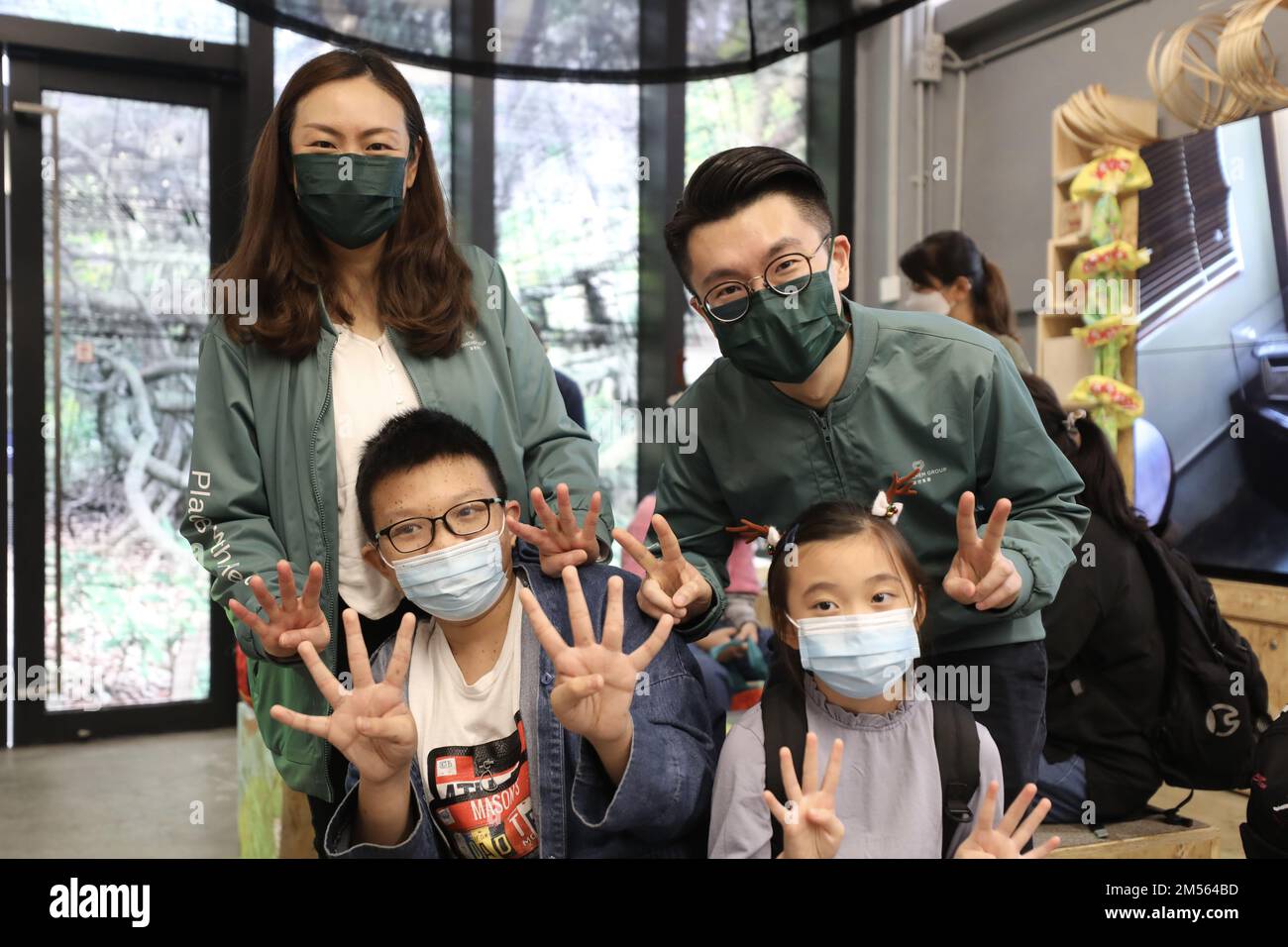 Chinachem Group Assistant Manager (CSR) Emily Shek Pui-yuk (back left) and Chinachem Group Senior Officer of Corporate Communications Charles Chui Pak-hung (back right) and Wan Chun-hin (front left), 13, and Luna Wong Tsk-ming, 8, have a photo taken after an OSC docent tour of Central market and the exhibition of HH Date with Hing Chun YeukHHfor hearing-impaired children and parents. The Operation Santa Claus (OSC) charity organises  the  tour of Central market and the exhibition for hearing-impaired children and parents. 11DEC22 SCMP / Xiaomei Chen Stock Photo