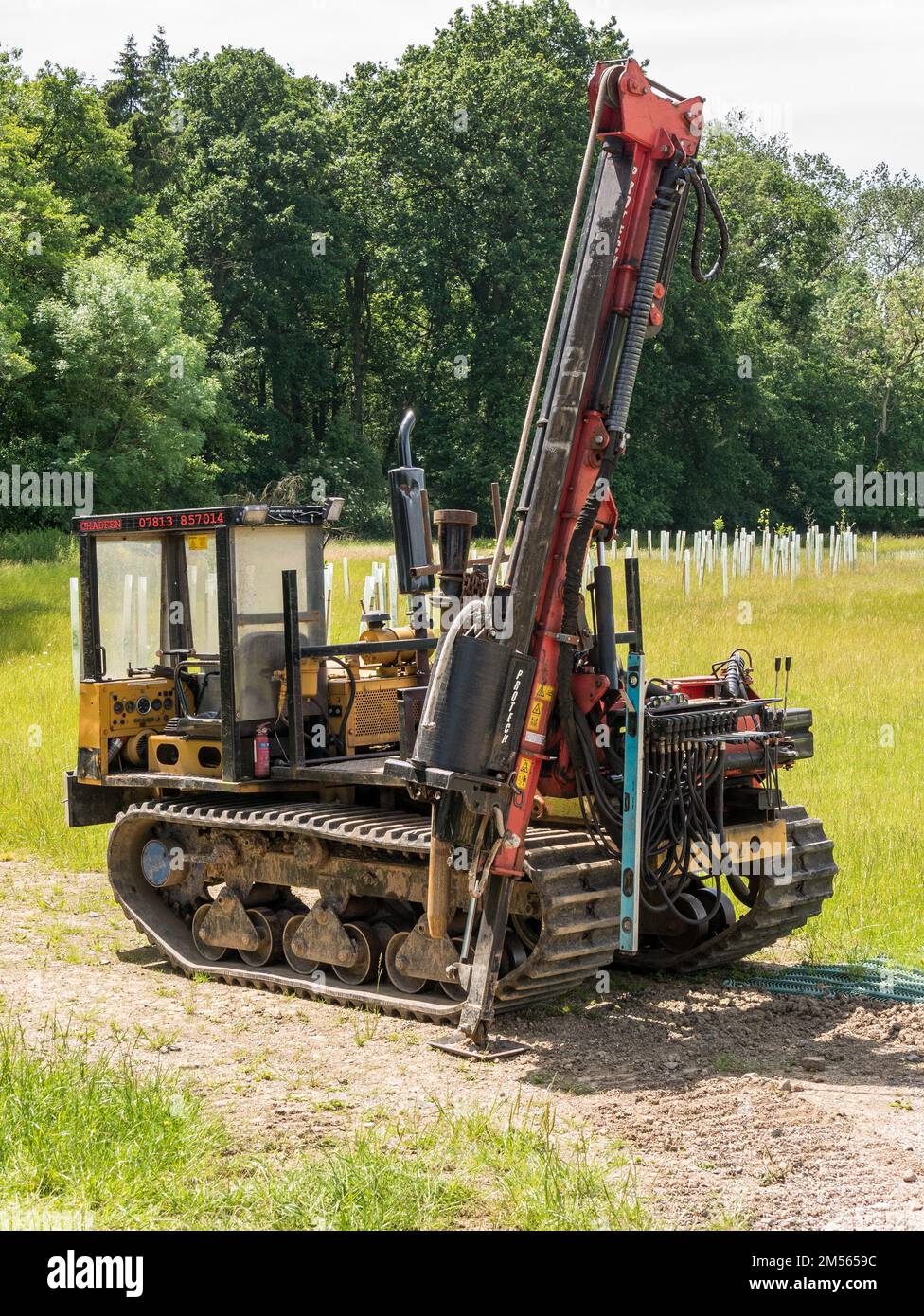 Old Morooka MST tracked fence post driver machine in grassy green field, Ticknall, Derbyshire, England, UK Stock Photo