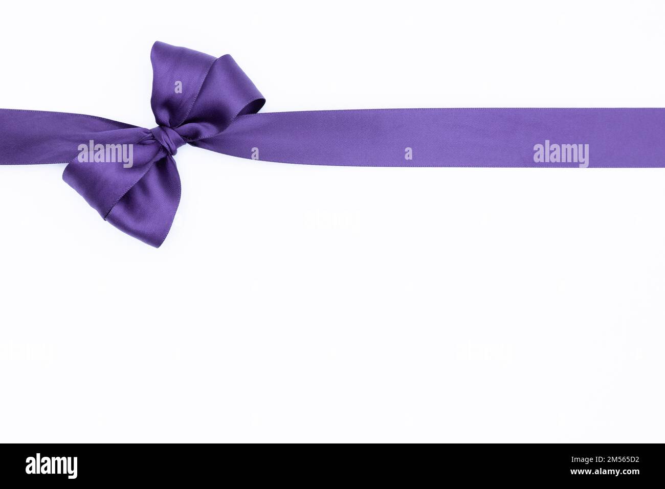 Purple gift wrap satin ribbon bow isolated on white background