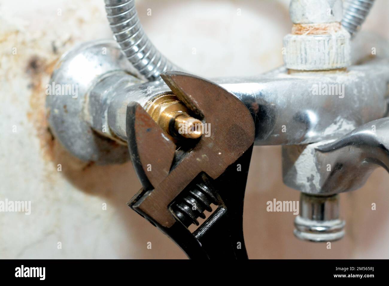 A plumber fixing a problem of a shower faucet tap spinning the