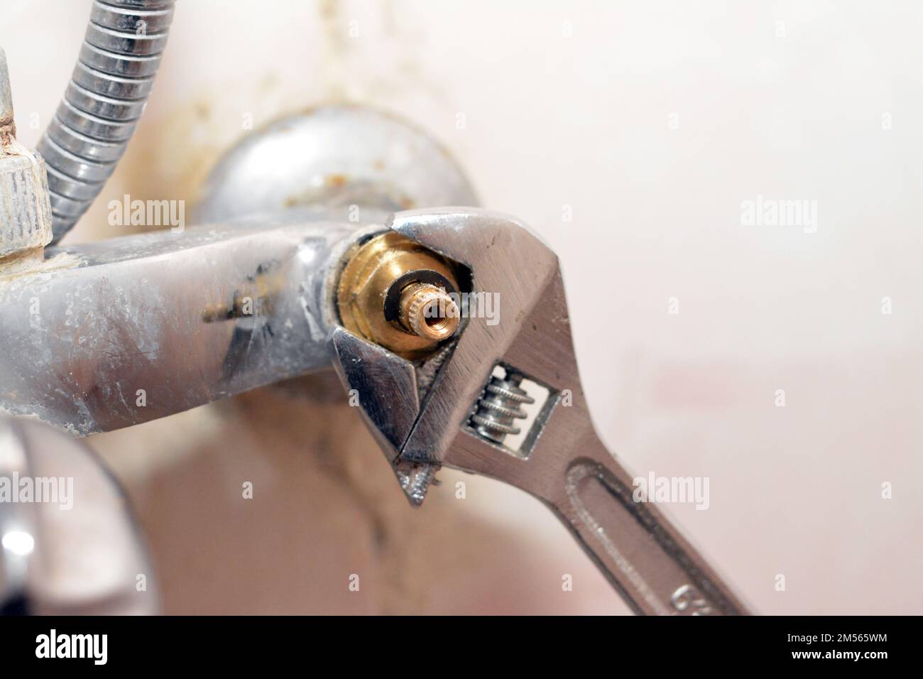 A plumber fixing a problem of a shower faucet tap spinning the