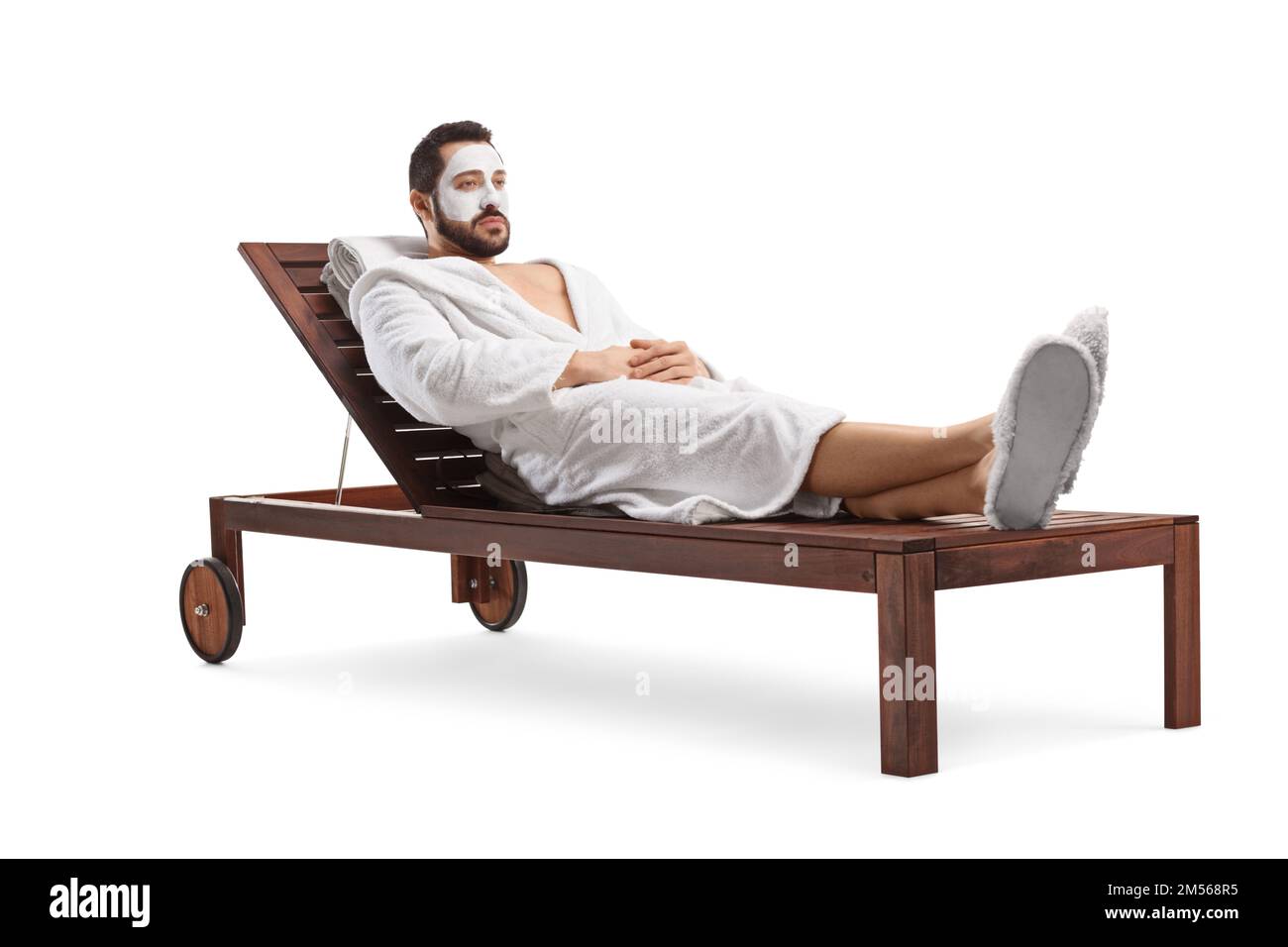 Man in a bathrobe with a face mask laying on a lounge chair isolated on