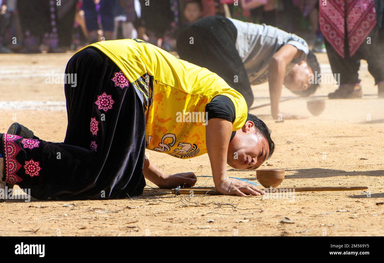 Hmong hill tribe men playing top spinning competition (traditional game of tujlub which involves
