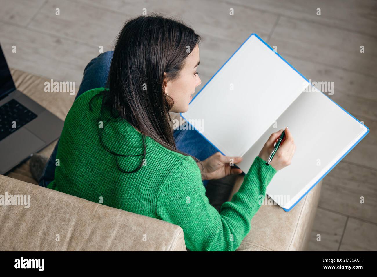 Woman with notepad at home on the couch Stock Photo - Alamy