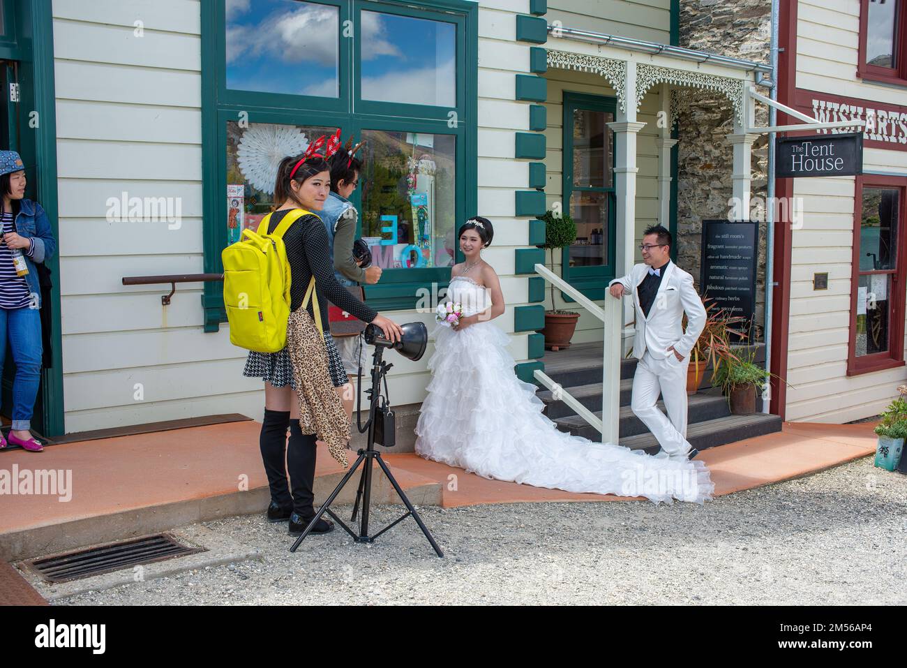 The photographer taking pictures of newlyweds by the cute buildings in Cromwell, Otago, New Zealand Stock Photo