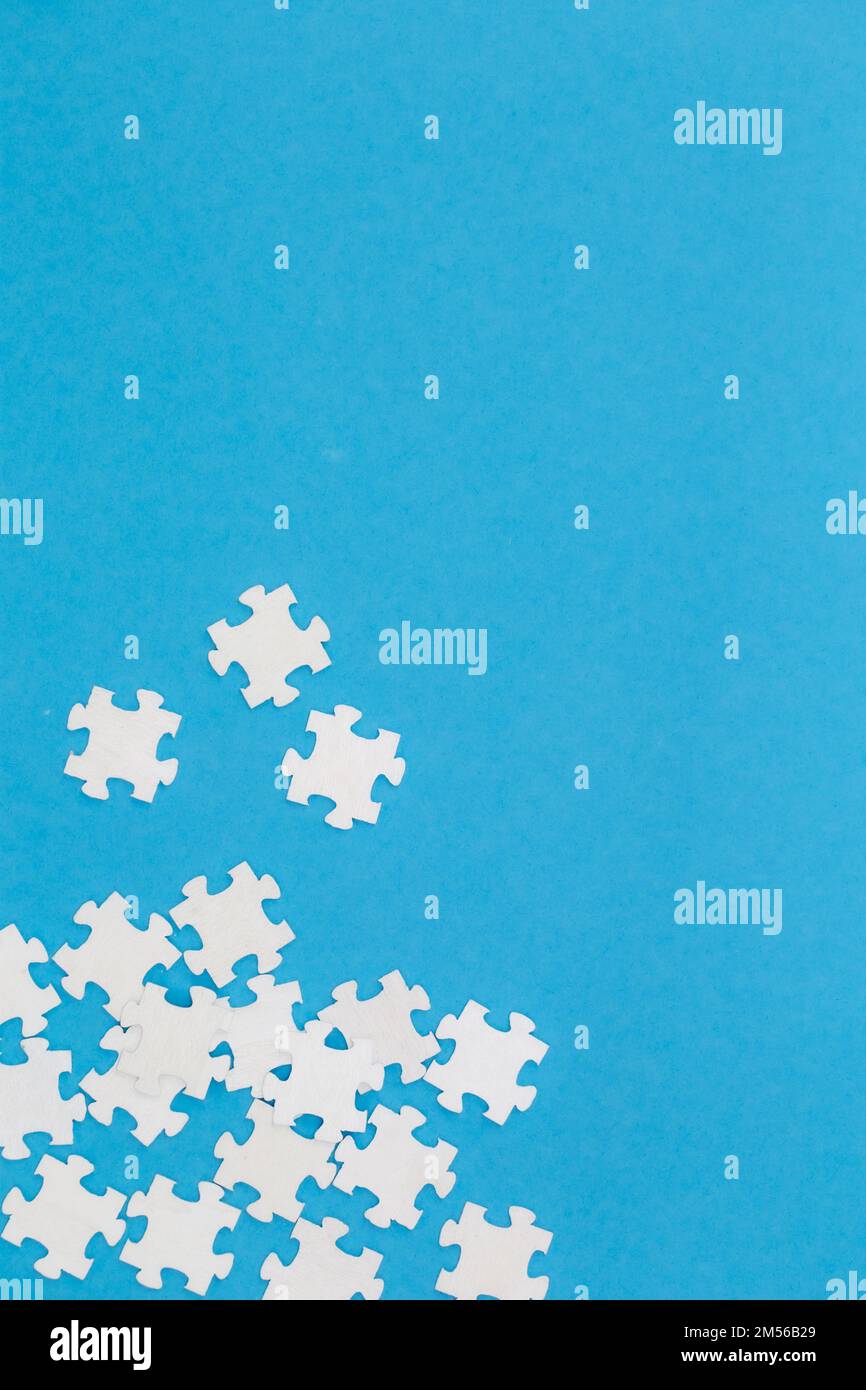 White puzzles on a blue background, flat lay. Stock Photo
