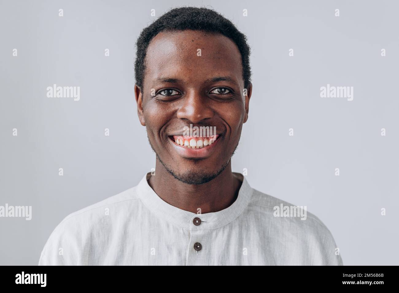 Portrait of handsome positive young African-American man in white shirt ...