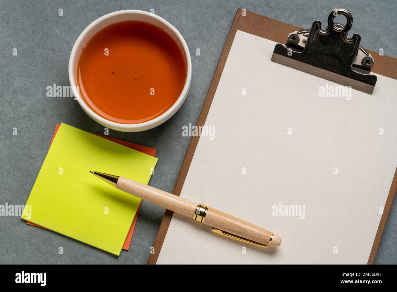 clipboard with a blank paper, desktop flat lay with a cup of tea ...