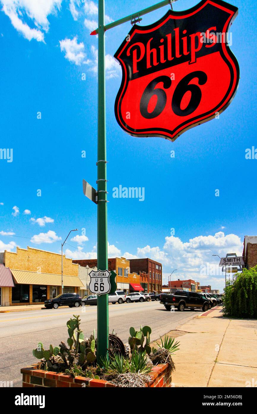 A vintage Phillips 66 gas station sign on Manvel Avenue, Route 66, in Chandler Oklahoma stands tall against a view of downtown. Stock Photo