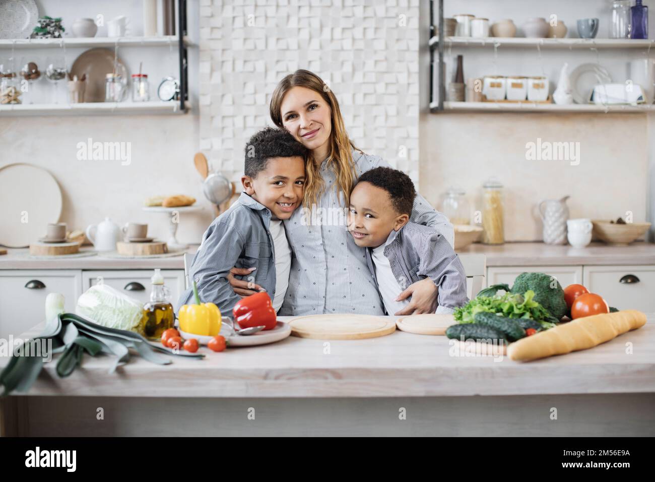 Mother and two children cooking and preparing a meal in the kitchen