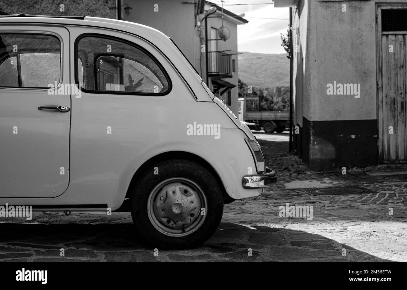A grayscale of a Fiat car parked in a street in Sarconi, Italy Stock ...