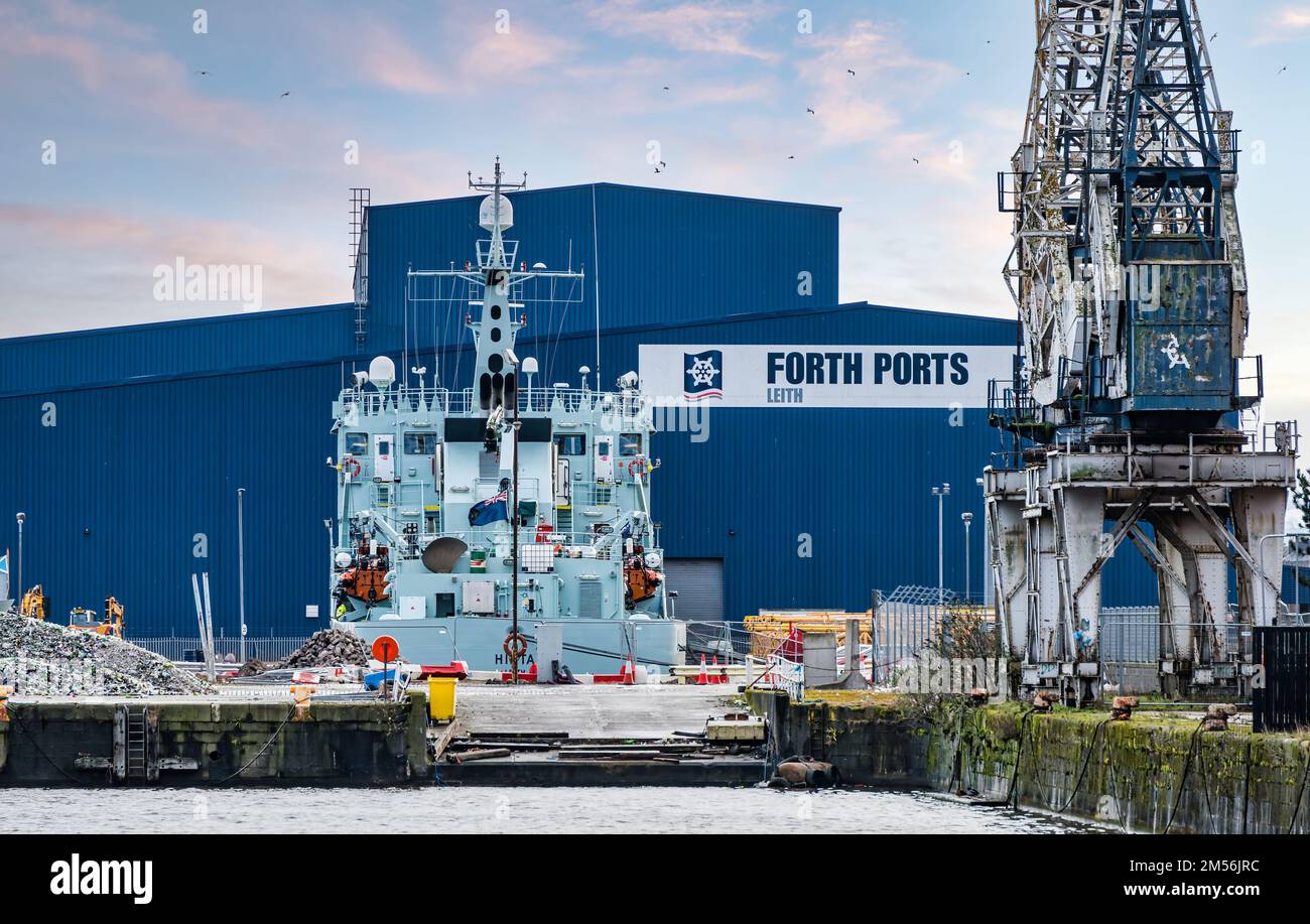 Fisheries patrol ship Hirta (Marine Scotland) docked by Forth Ports big blue shed, Leith Harbour, Edinburgh, Scotland, UK Stock Photo