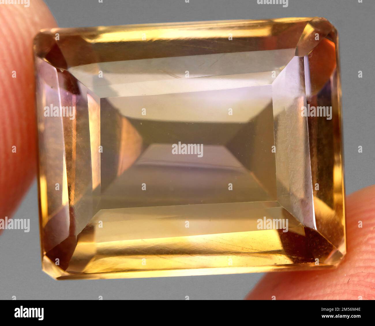 Amerite Color Natural stone bi color ametrine on gray background Stock Photo - Alamy