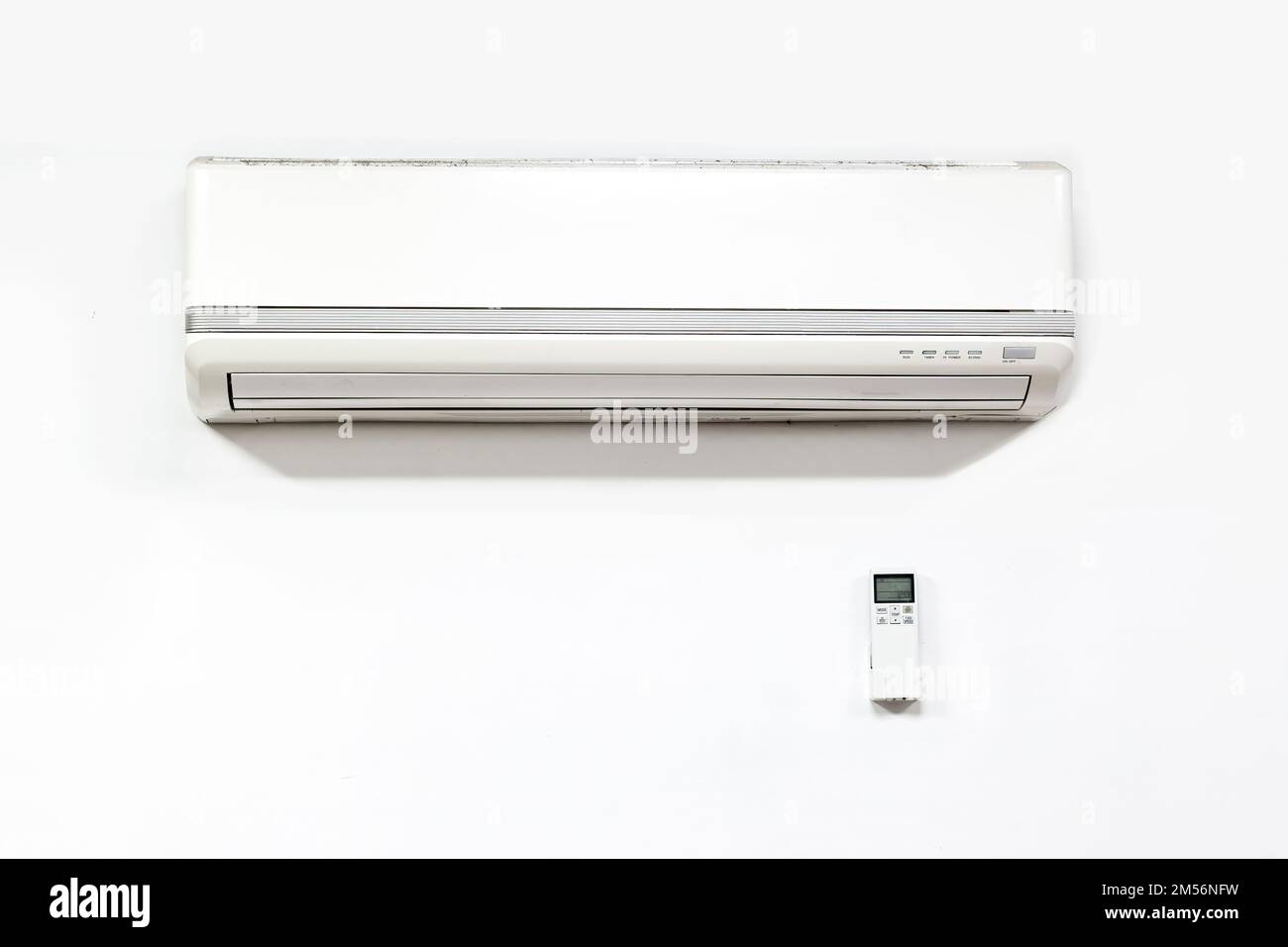 White air conditioner hanging on white wall.Dirty air conditioner. Stock Photo