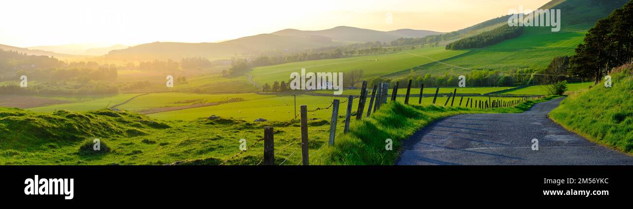 Panorama Of A Single-Track Road Snaking Through The Beautiful Scottish Countryside At Sunset Stock Photo