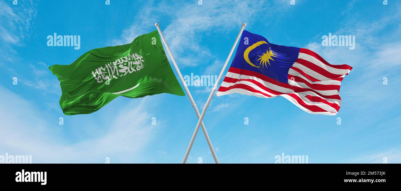 two crossed flags Malaysia and Saudi Arabia waving in wind at cloudy sky. Concept of relationship, dialog, travelling between two countries. 3d illust Stock Photo