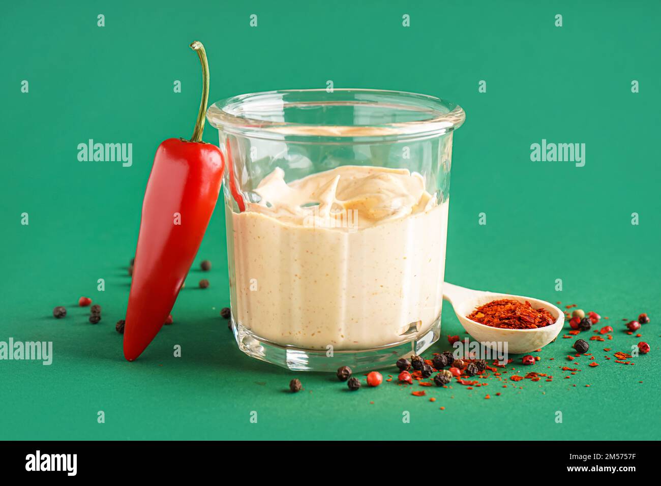 Glass of tasty chipotle sauce on green background Stock Photo