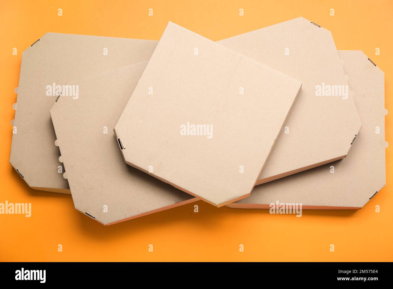 Stack of cardboard pizza boxes on color background Stock Photo