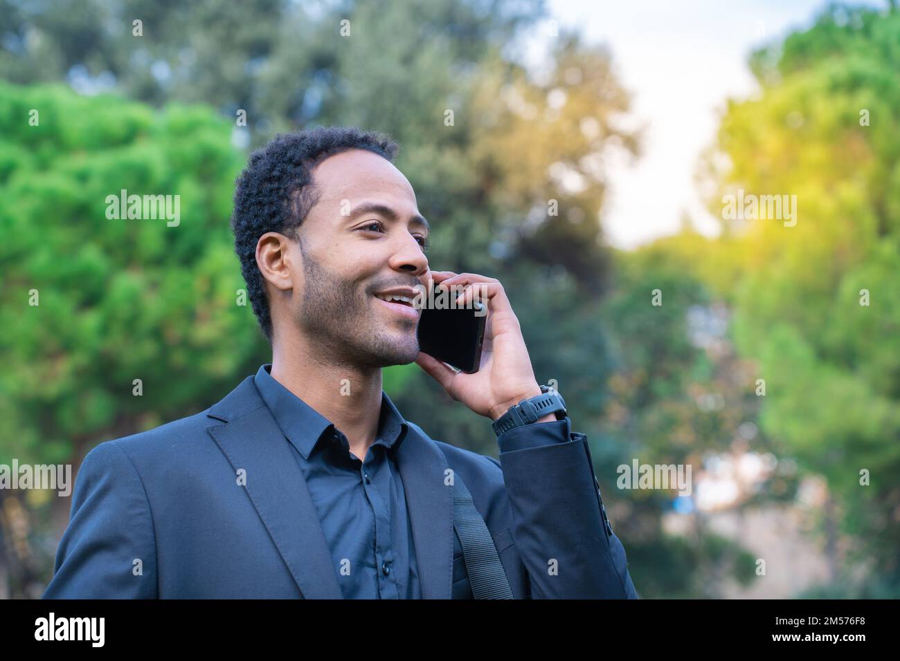 Close up portrait of attractive young african american man talking on mobile phone outdoors Stock Photo