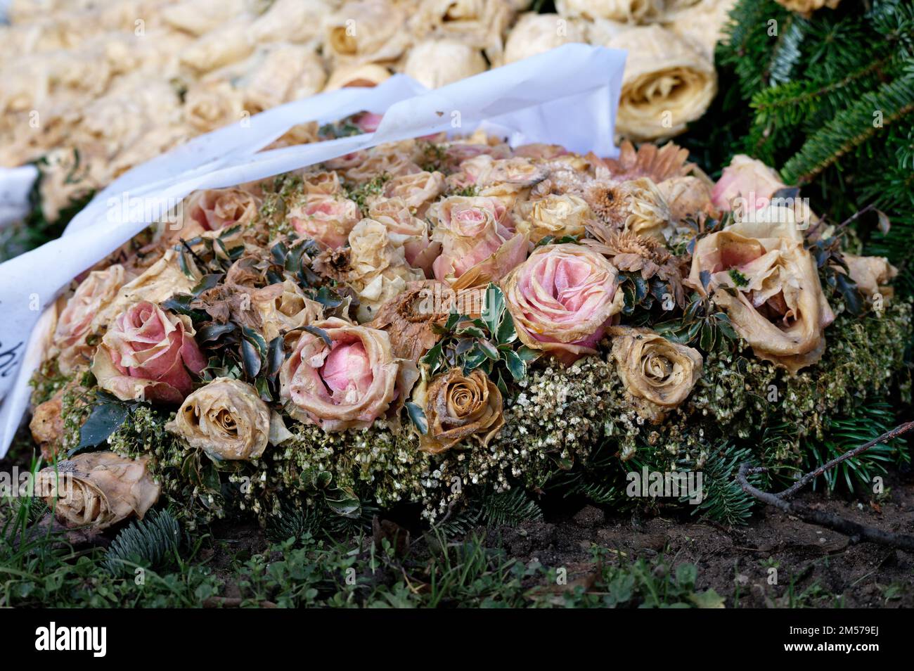 pastel withered flower decoration with roses on a grave Stock Photo