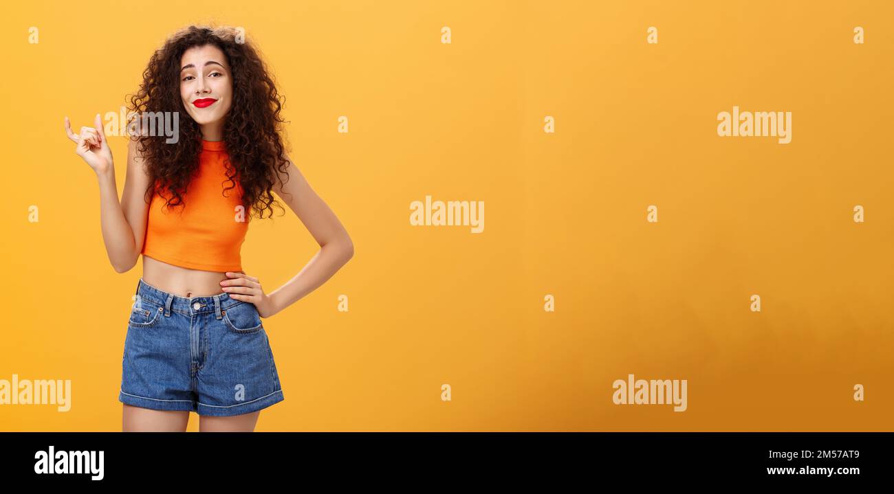 Girl needs bigger size to impress. Carefree picky stylish urban female with  curly hairstyle red lipstick in cropped top shaping small or little thing  Stock Photo - Alamy