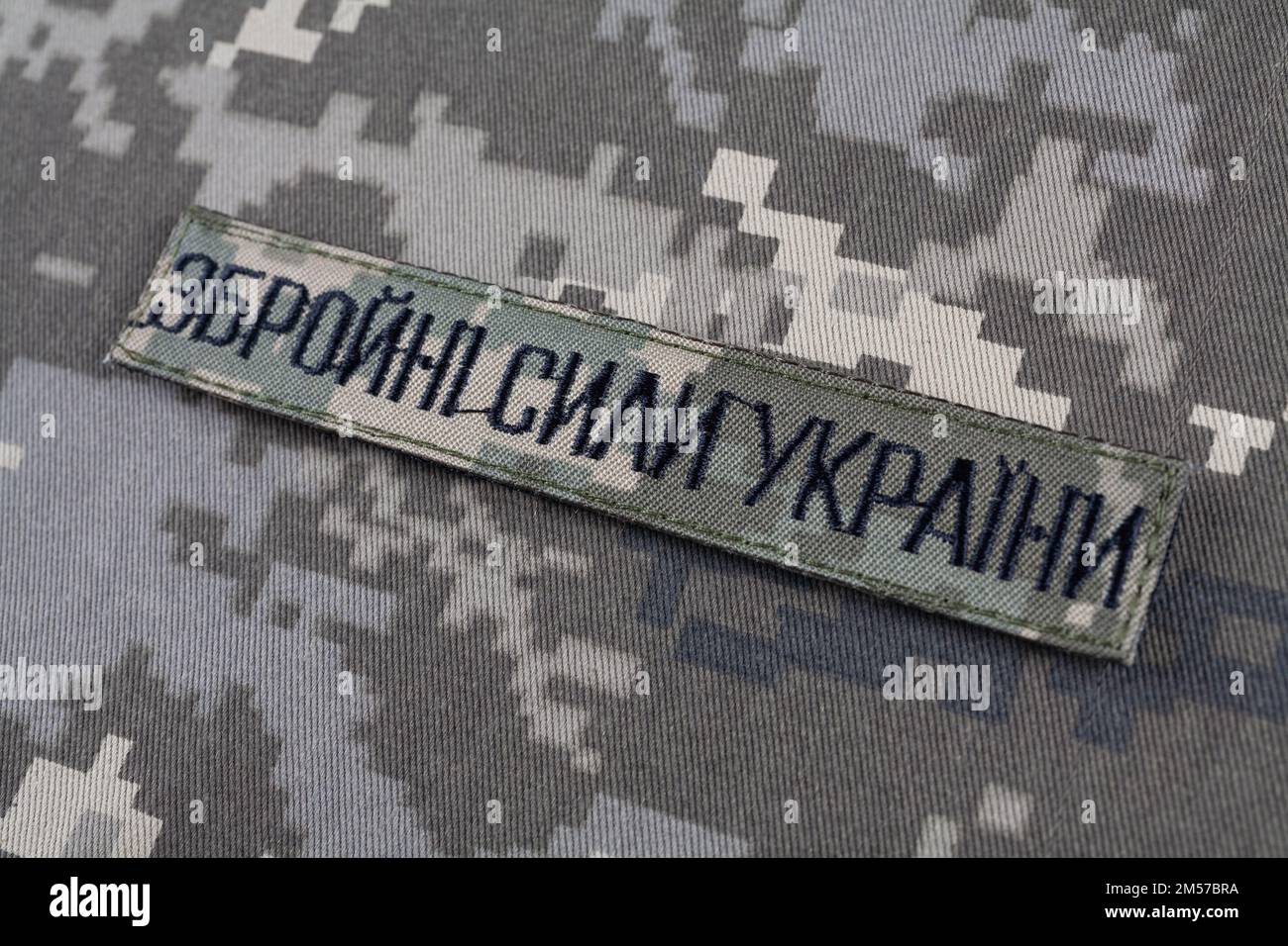 KYIV, UKRAINE - October 5, 2022. Russian invasion in Ukraine 2022. Ukraine Army uniform insignia badge on camouflaged uniform background. Text in ukra Stock Photo